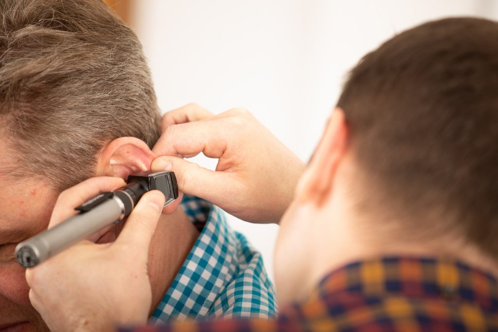 Audiologist Simon Howe examining a client's ear